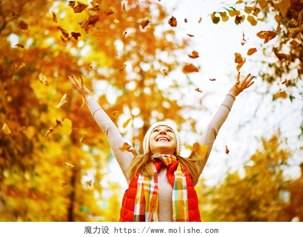 快乐的女孩抛散公园的落叶快乐的女孩抛出了秋天的落叶，在园内为户外行走